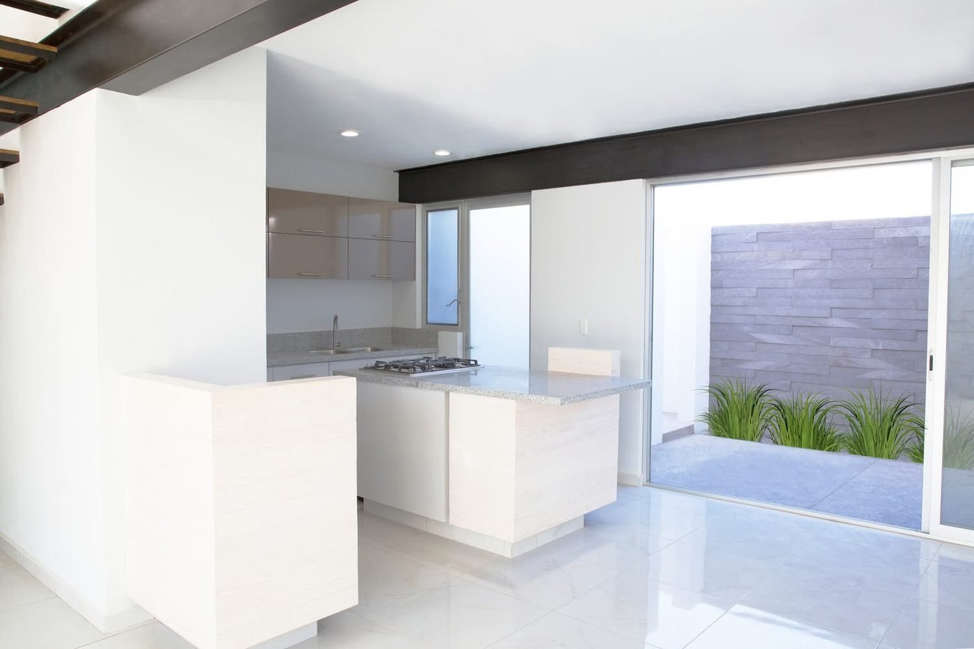 Cocina minimalista con isla de piedra y acabados claros