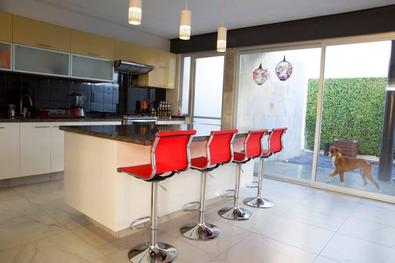 Cocina con gabinetes amarillos y bancos rojos