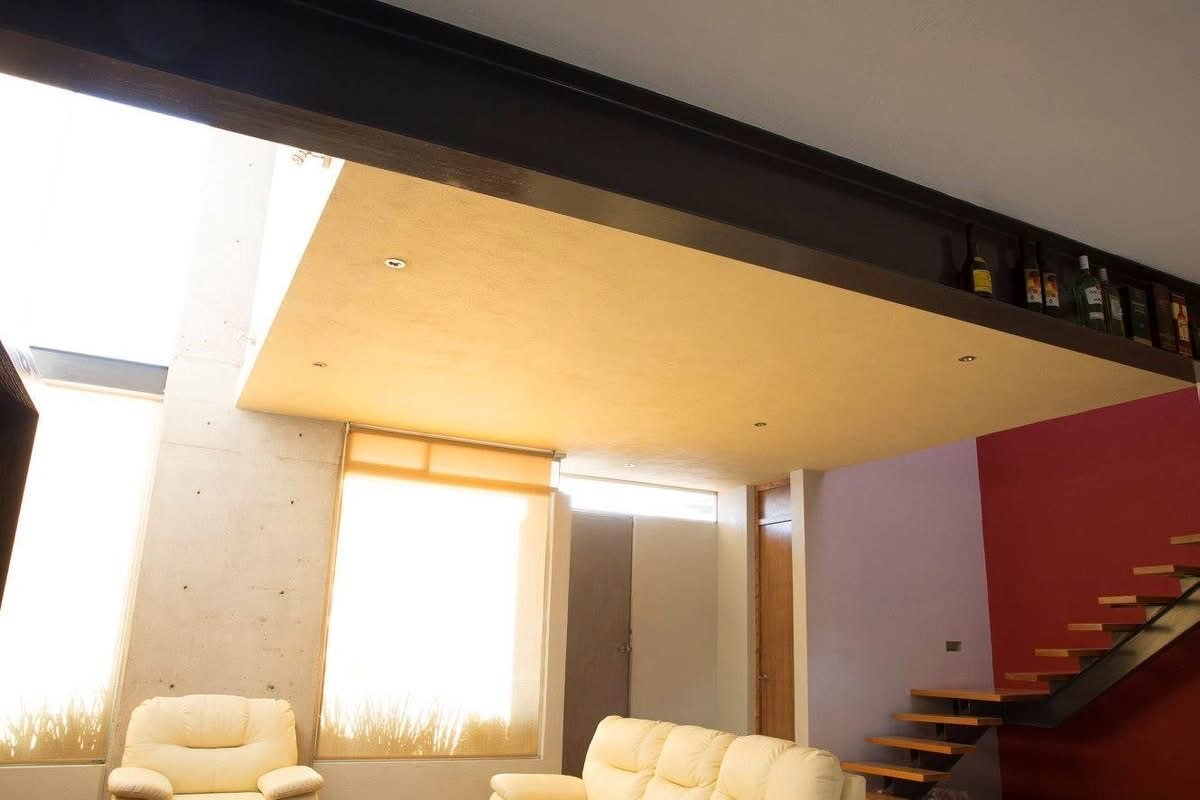 Sala con escalera suspendida y muro rojo