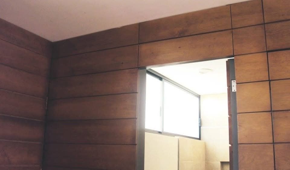 Muro de paneles de madera con acceso a baño